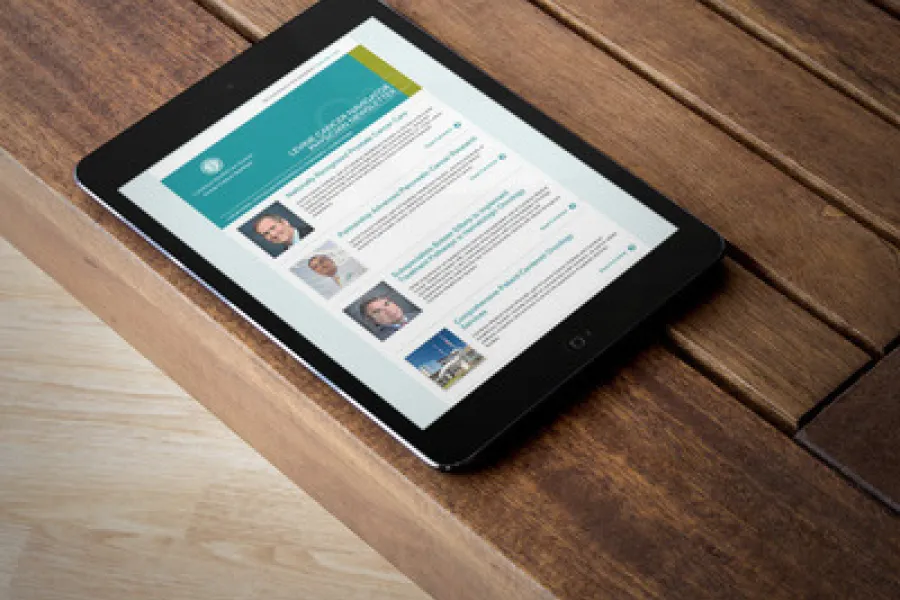 A tablet showing the LCN email newsletter on a wood floor.